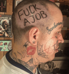 a man with a lot of tattoos on his face has the words fuck a job written on his head