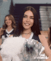 a cheerleader is smiling and holding a pom pom with xtecrystali written on the bottom