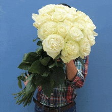 a person holding a large bouquet of white roses