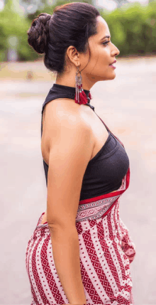 a woman wearing a black top and red and white striped skirt