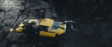 a yellow car is flying through the air in a dark cave .