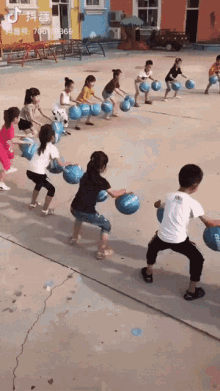 a group of children are playing a game of tug of war with balls that have the word ' slazenger ' on them