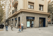 a group of people walking in front of a store called aural