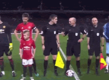 a group of soccer players and referees stand on a field with a yellow flag that says 1 on it