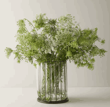 a glass vase filled with green and white flowers on a table