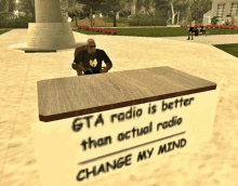 a man sits at a table with a sign that says " gta radio is better than actual radio "