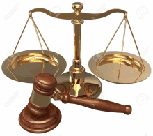 a wooden judge 's gavel sits next to a scale of justice