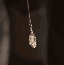 a close up of a crystal hanging from a chain