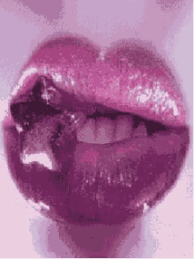 a close up of a woman 's lips with purple lipstick on .