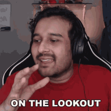 a man wearing headphones and a red shirt says " on the lookout "