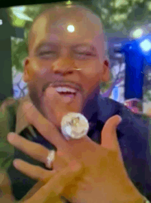 a man is wearing a ring on his finger and smiling