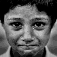 a close up of a child 's face with tears coming out of his eyes