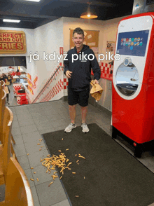 a man standing next to a vending machine that says ja kdyz piko piko