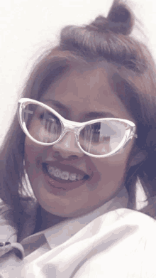 a girl with braces on her teeth wears sunglasses