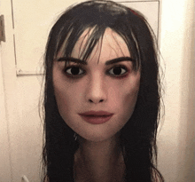 a close up of a woman 's face with a white board in the background