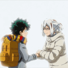 a boy with a backpack holds hands with a girl with a scarf around her neck