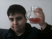 a young boy is holding a pitcher with red liquid in it