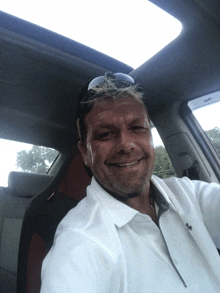 a man in a white shirt is sitting in a car