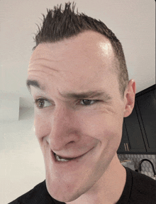 a close up of a man 's face with a black shirt on