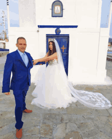 a bride and groom pose for a picture in front of a church