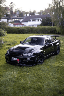 a black sports car with a license plate that says gnm 059 is parked in a grassy field