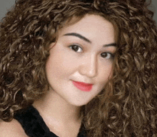 a woman with curly hair wearing a black top