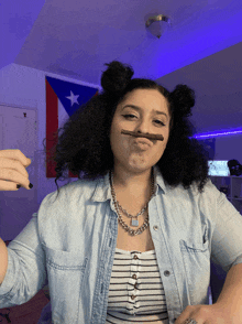 a woman wearing a striped top and a denim shirt has a fake mustache made out of her hair