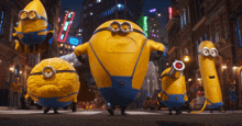 a group of minions are standing on a city street at night