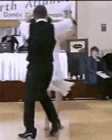 a man and a woman are dancing on a dance floor in front of a sign that says north atlantic dance championship