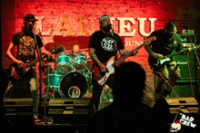 a band playing in front of a sign that says " bad crew " on it