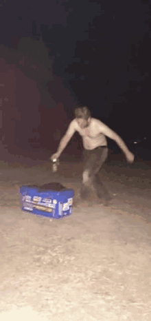 a man without a shirt is standing next to a pepsi cooler