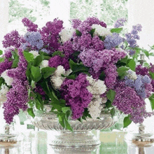 a vase filled with purple and white flowers on a table .