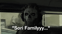 a man wearing a skull mask and headphones says " sori familyyy " while sitting in a car .