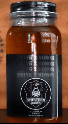 a bottle of thirteen monkeys all american whiskey sits on a wooden table