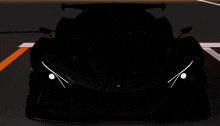 the front of a black sports car with white lights