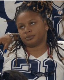 a woman with dreadlocks is wearing a dallas jersey