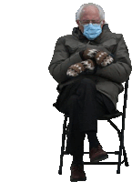 a man wearing a face mask and mittens is sitting on a chair .