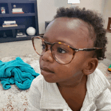 a young child wearing glasses looks at something