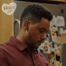 a man in a red shirt is standing in front of a refrigerator with a heart that says hello again on it