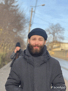 a man with a beard is wearing a black jacket and a black hat with faceapp written on the bottom