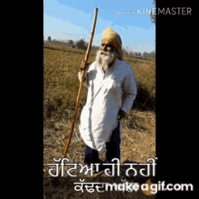 a man with a beard is holding a stick in a field with the words made with kinemaster on the bottom right