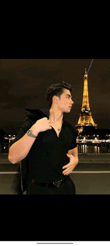 a man in a black shirt with the eiffel tower in the background