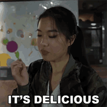 a woman in a camouflage jacket says it 's delicious while eating