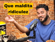 a man sitting in front of a microphone with a yellow sign that says que maldita ridiculez