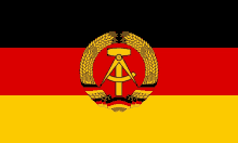 a black red and yellow flag with a gold emblem