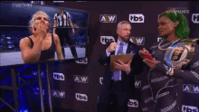 a man in a suit and tie is holding a clipboard while talking to a woman in a wrestling outfit