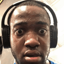 a sweaty man wearing headphones looks surprised