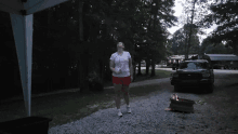 a woman standing next to a fire pit with a ford truck parked behind her