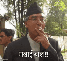 a man in a suit and hat is smoking a cigarette with a caption in a foreign language .