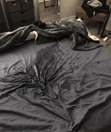 a bed with a blanket on it and a stain on it